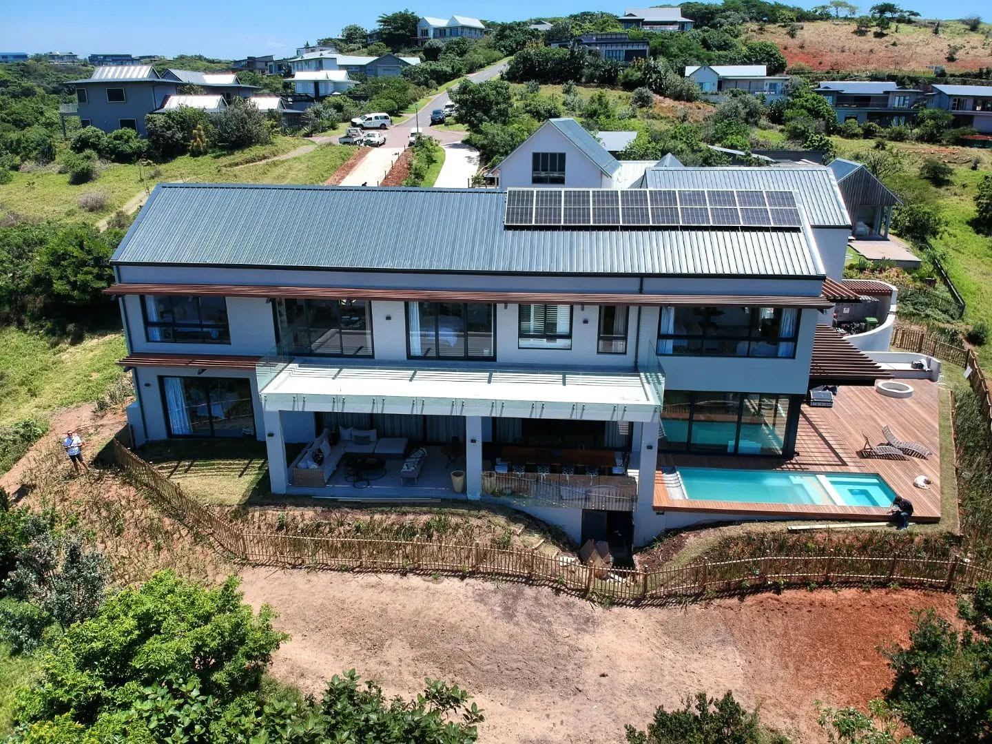 Aerial view of a hillside home with solar roof and pool, Durban