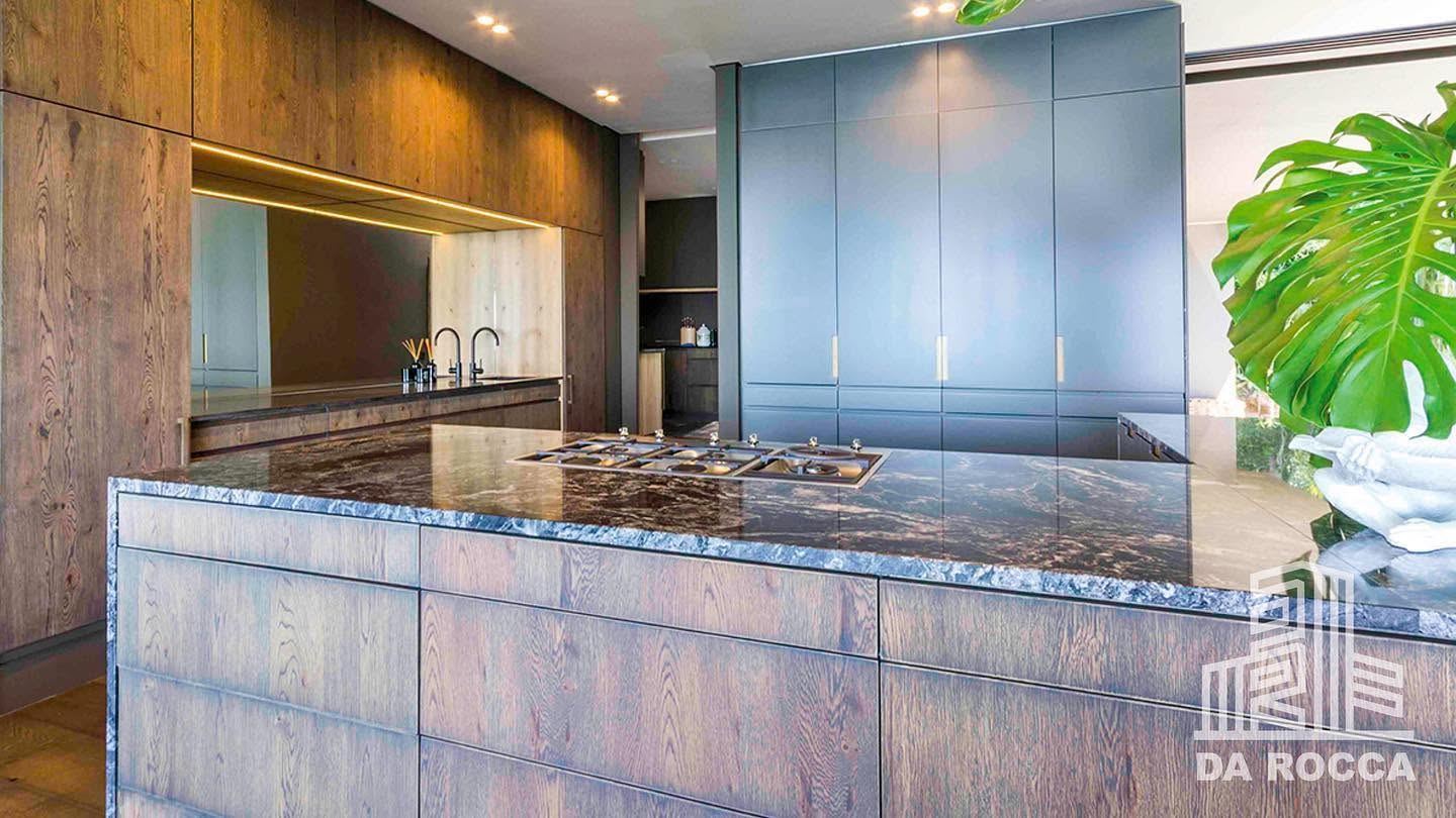 Dark stone waterfall-edge kitchen island in a renovated home